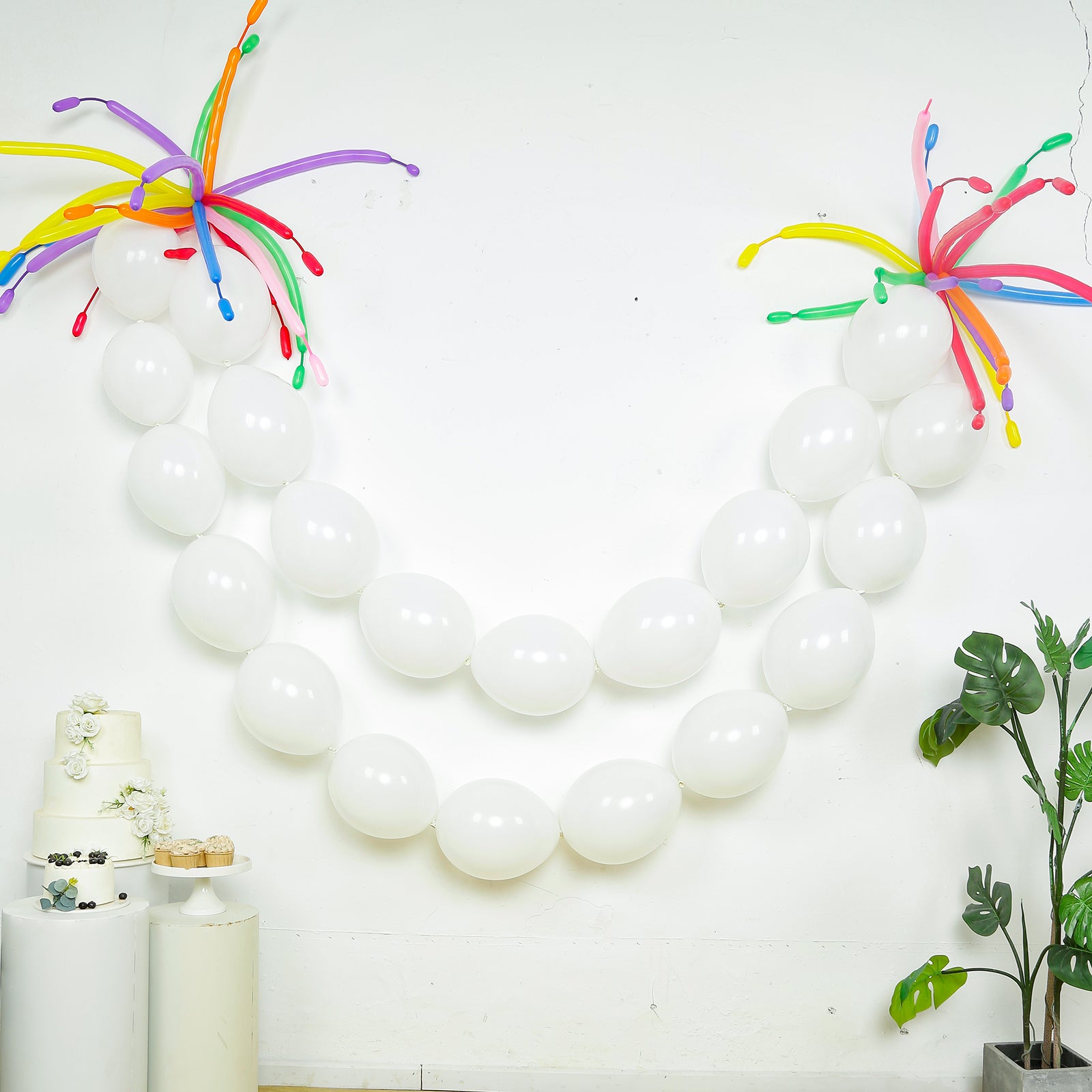 Matte pastel white biodegradable linking balloons in a decorative arrangement.