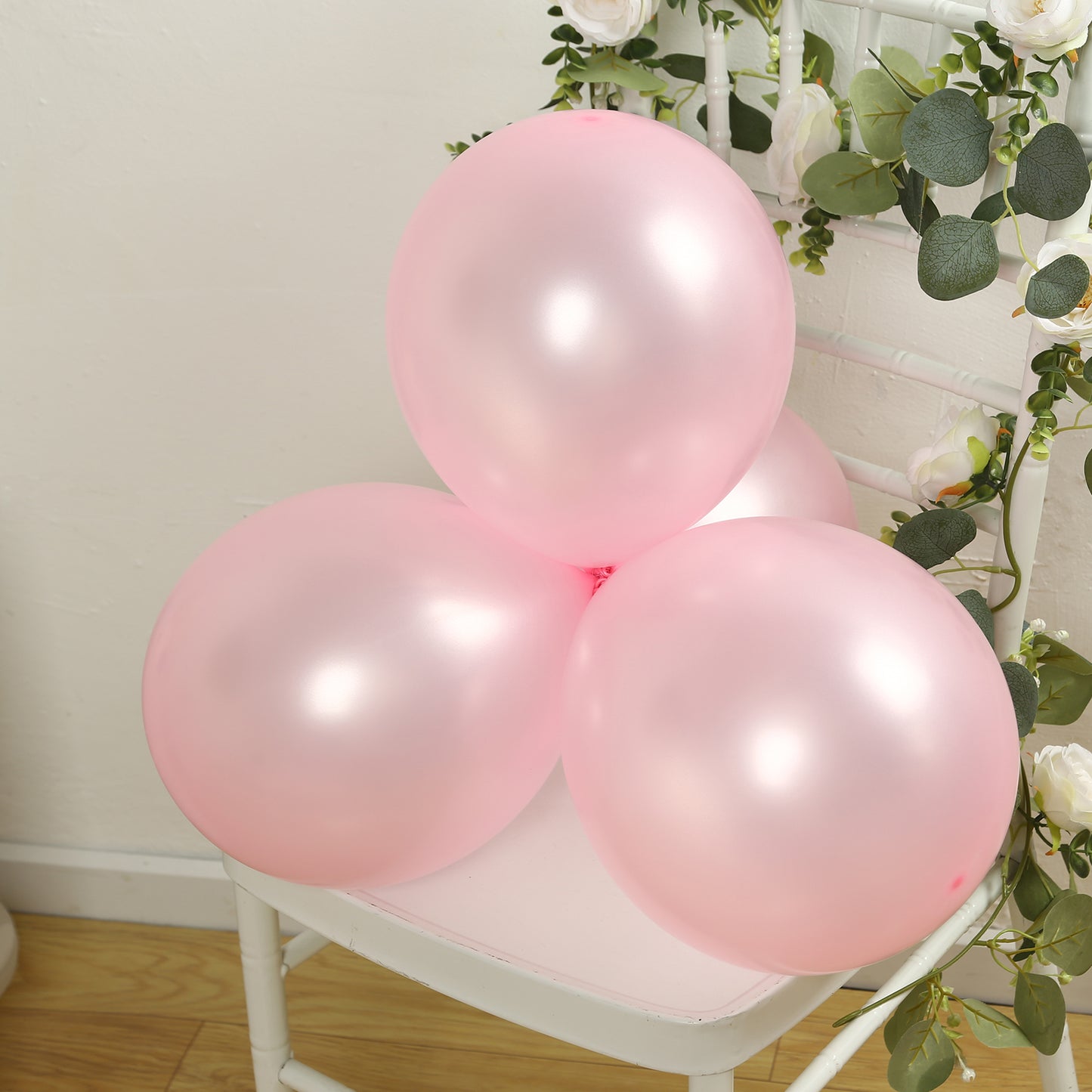 Blush biodegradable balloons on a chair, perfect for eco-friendly parties.