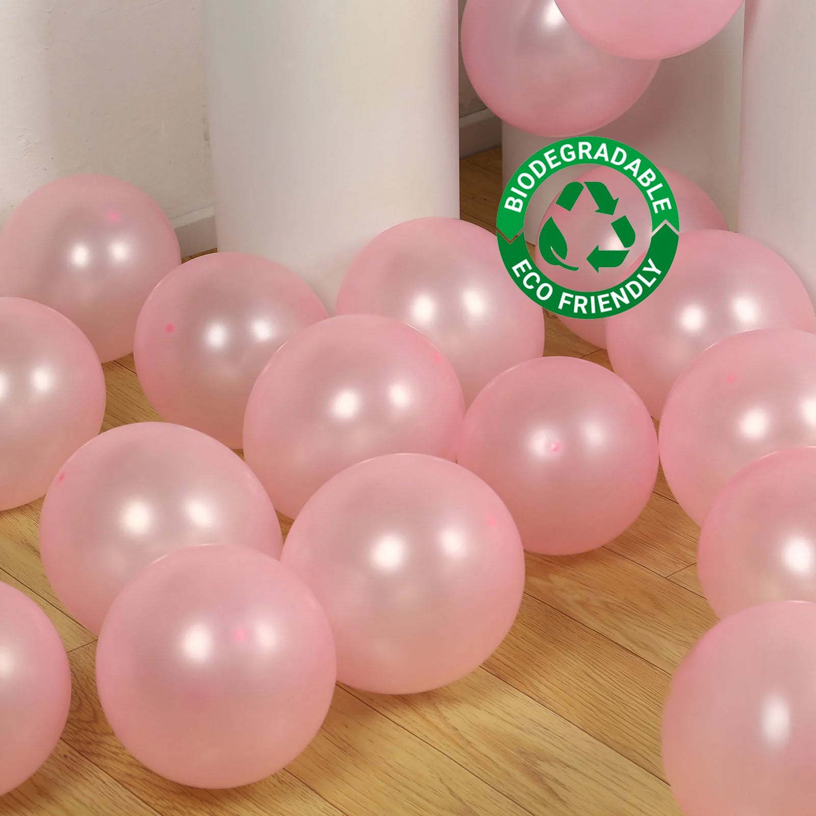 Blush biodegradable balloons on a wooden floor, eco-friendly and strong.