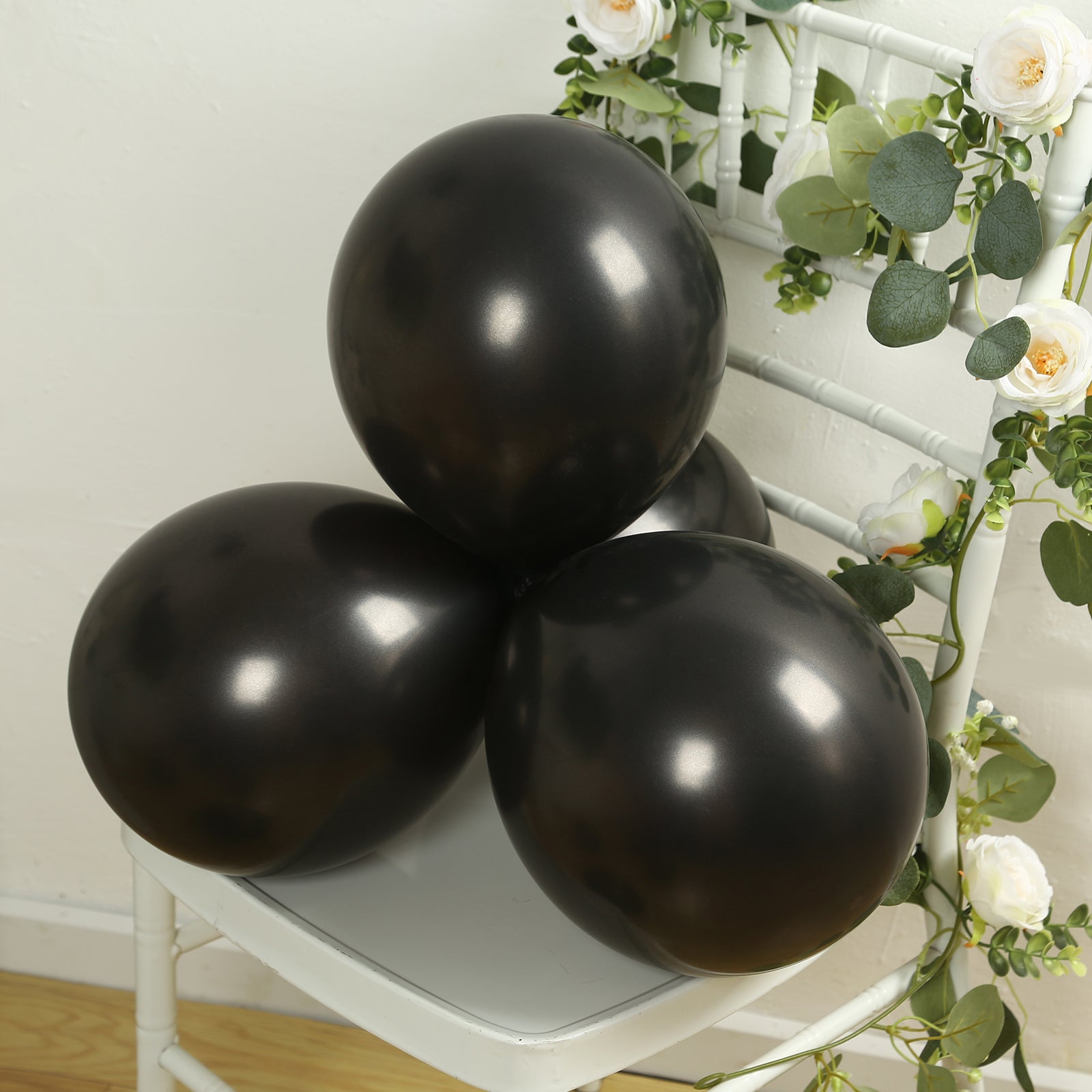 Black biodegradable balloons on a chair, eco-friendly latex party supplies.