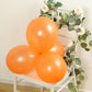 Orange biodegradable balloons on a chair with greenery.