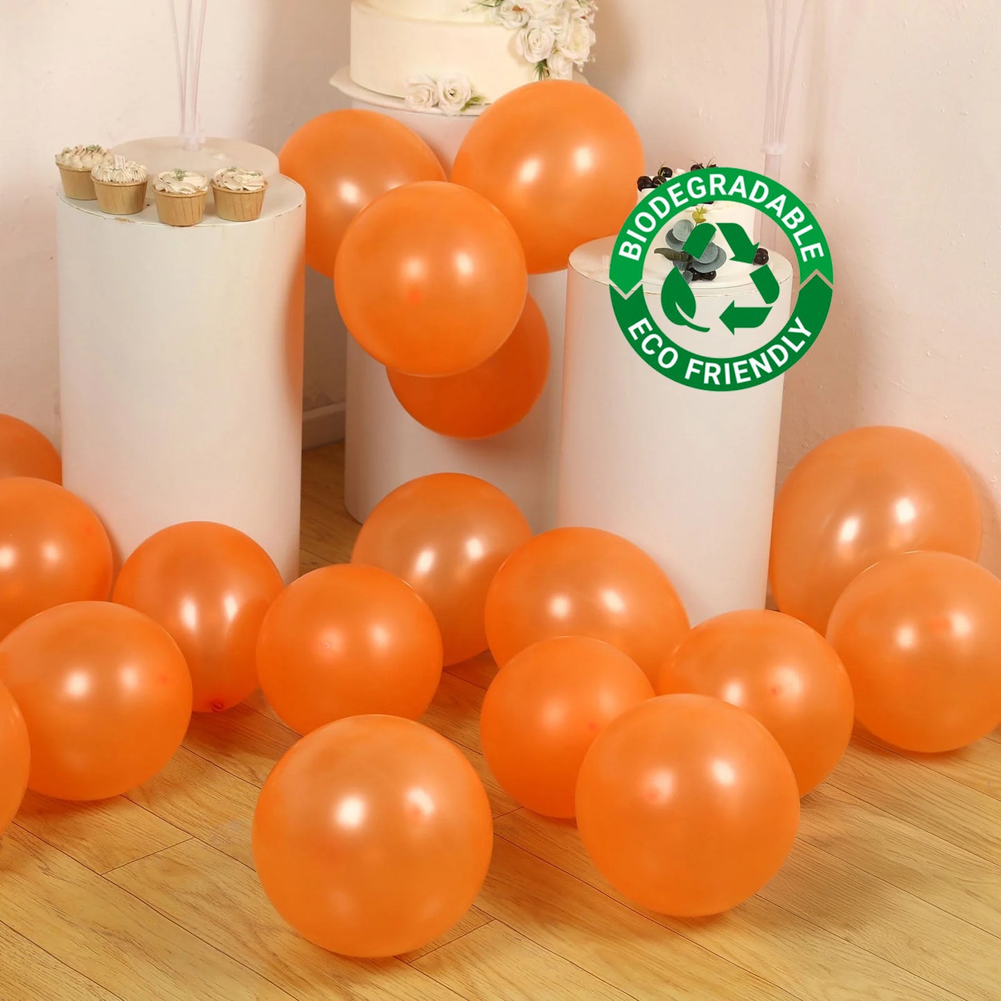 Orange biodegradable balloons scattered on the floor for a party setting.