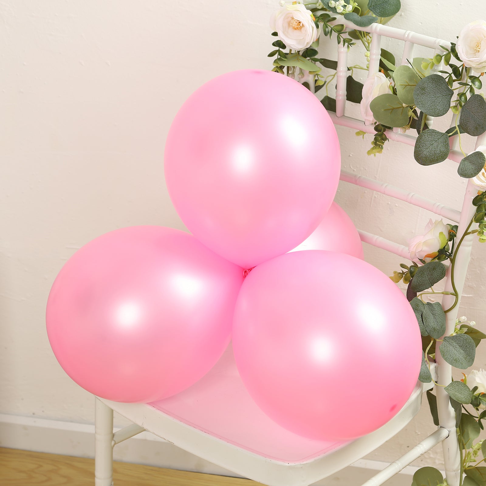 Pink biodegradable balloons on a chair, perfect for eco-friendly parties.