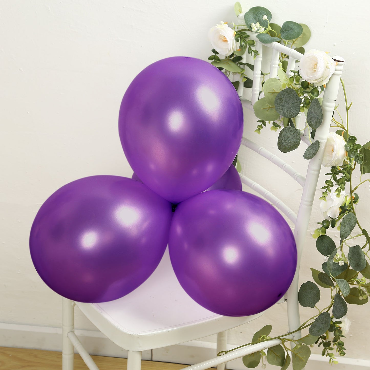 Purple biodegradable balloons in a cluster on a white chair.