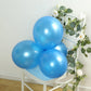Bright blue biodegradable balloons arranged on a chair with greenery.