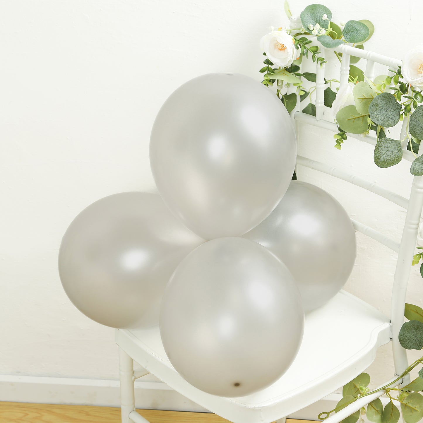 Silver biodegradable balloons arranged on a chair, perfect for eco-friendly parties.