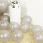 Silver biodegradable balloons scattered on a wooden floor.