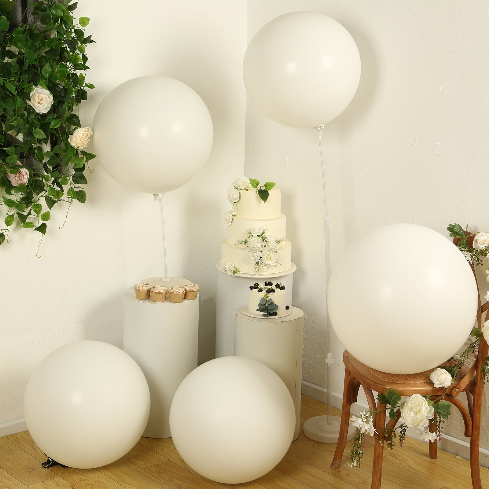 Large off white biodegradable balloons arranged with floral decor.