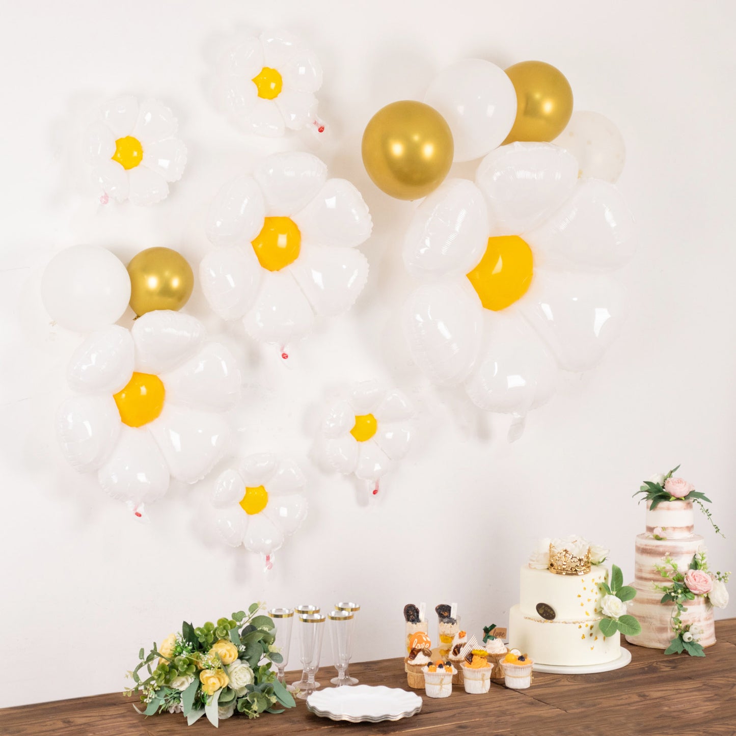 White daisy flower-shaped balloons with gold accents for party decorations.