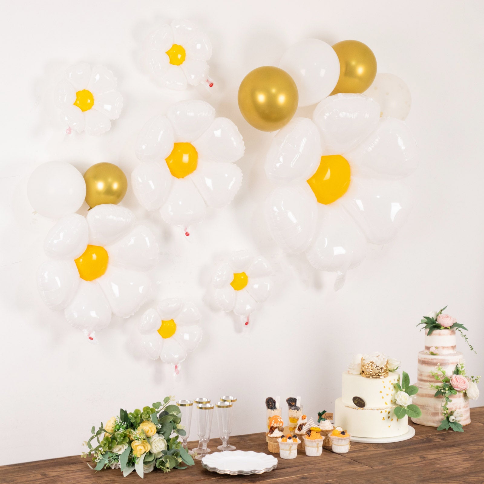 White daisy flower-shaped balloons with gold accents for party decorations.