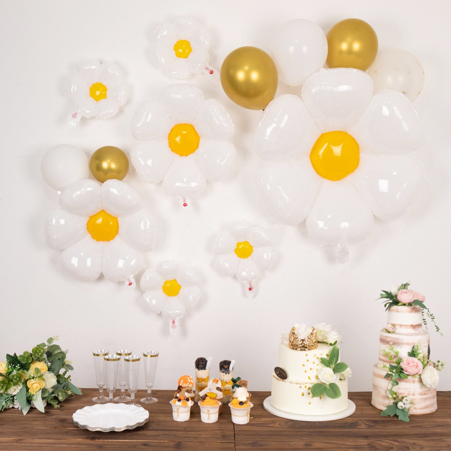 White daisy flower-shaped balloons with yellow centers for party decorations.