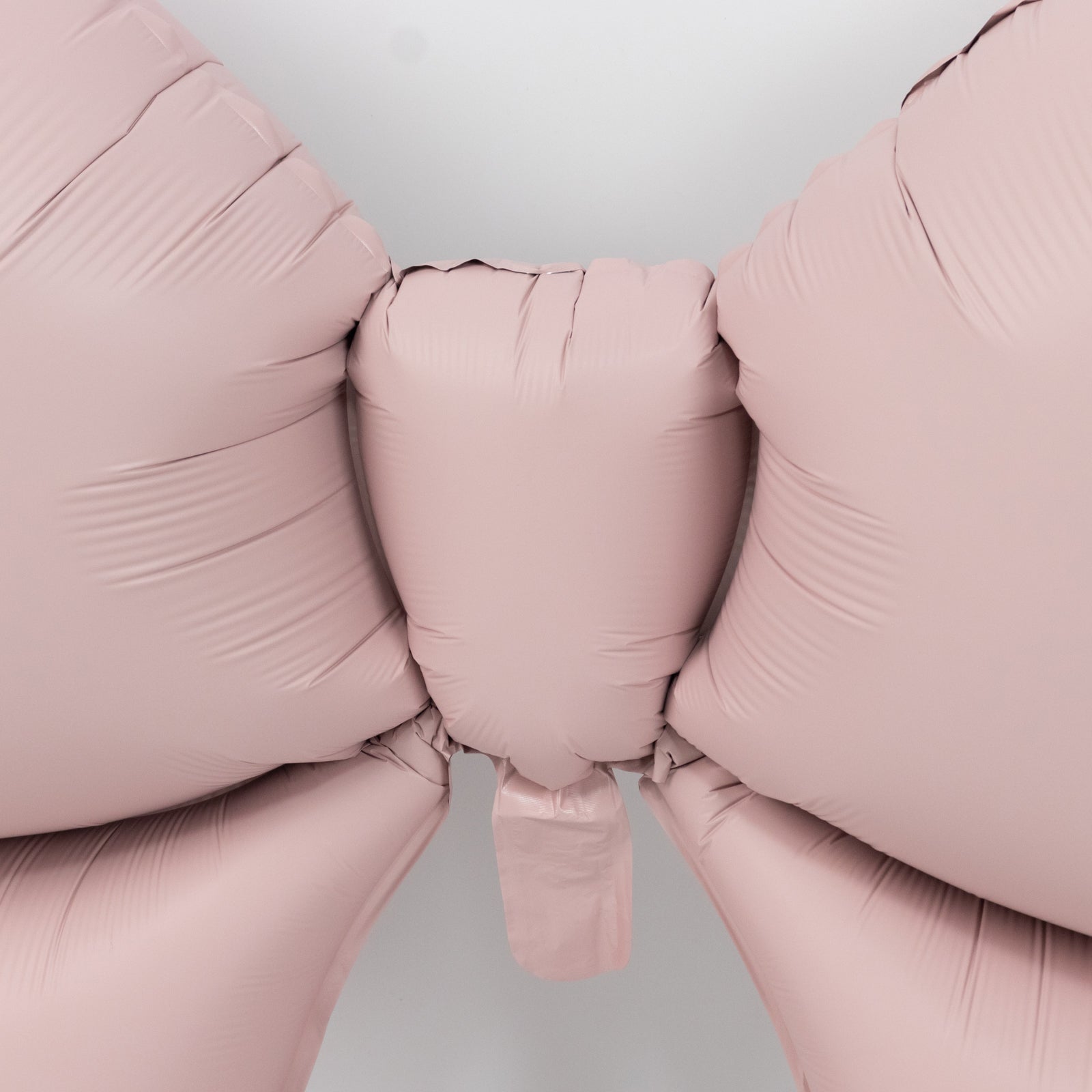 Matte blush decorative foil bow balloons for party backdrop and styling.
