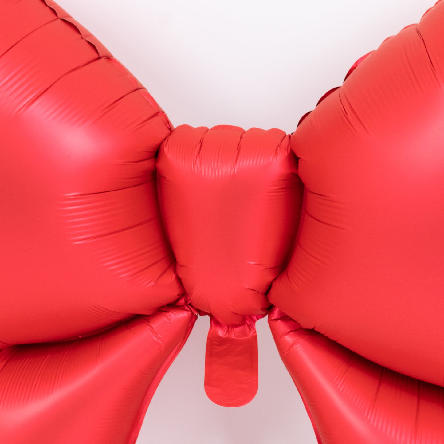 Matte red giant decorative foil bow balloon for event styling.