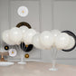 White balloon centerpieces in a clear holder on a table.