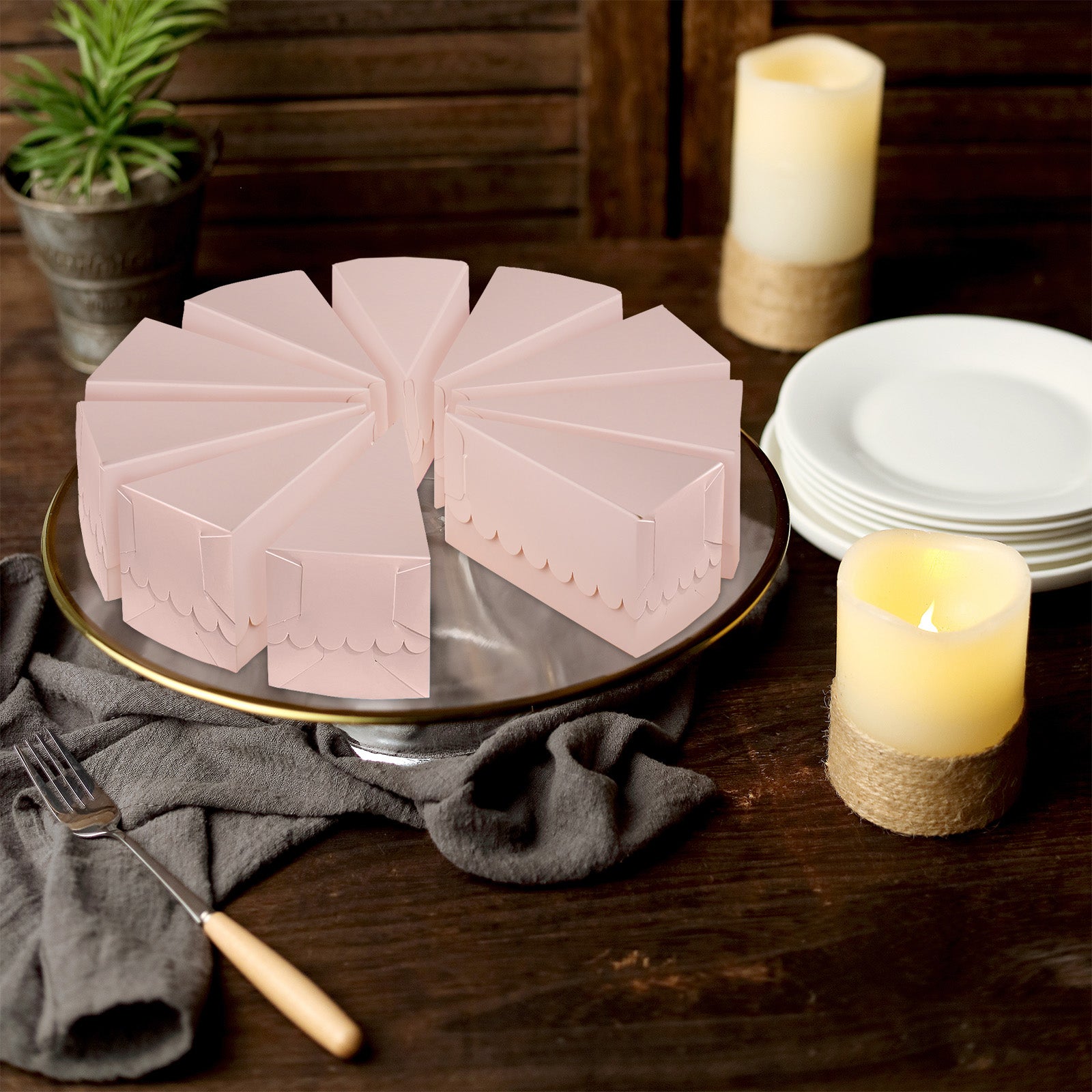 Blush triangular paper cake boxes arranged on a serving platter.