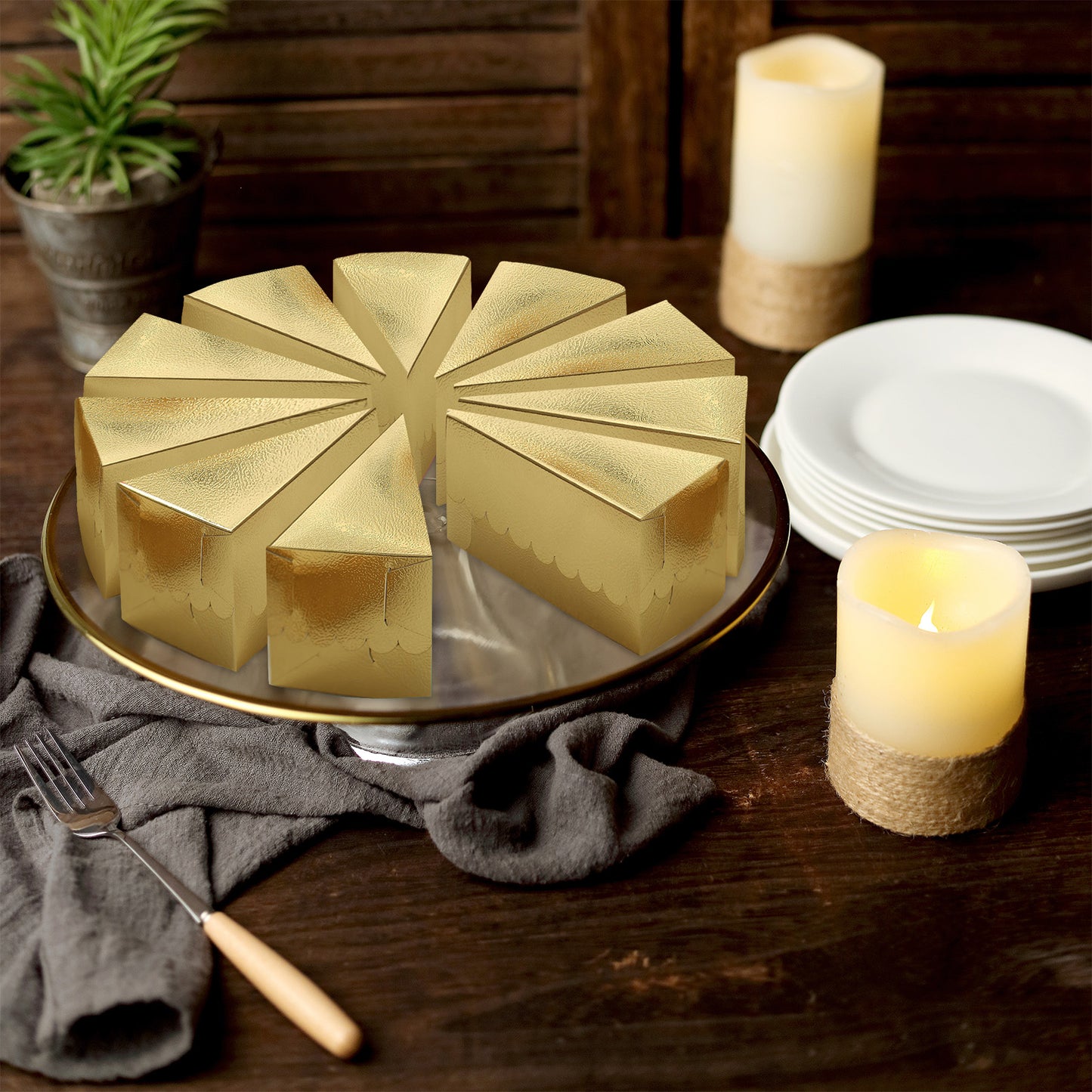 Metallic gold triangular paper cake boxes on a dessert platter.