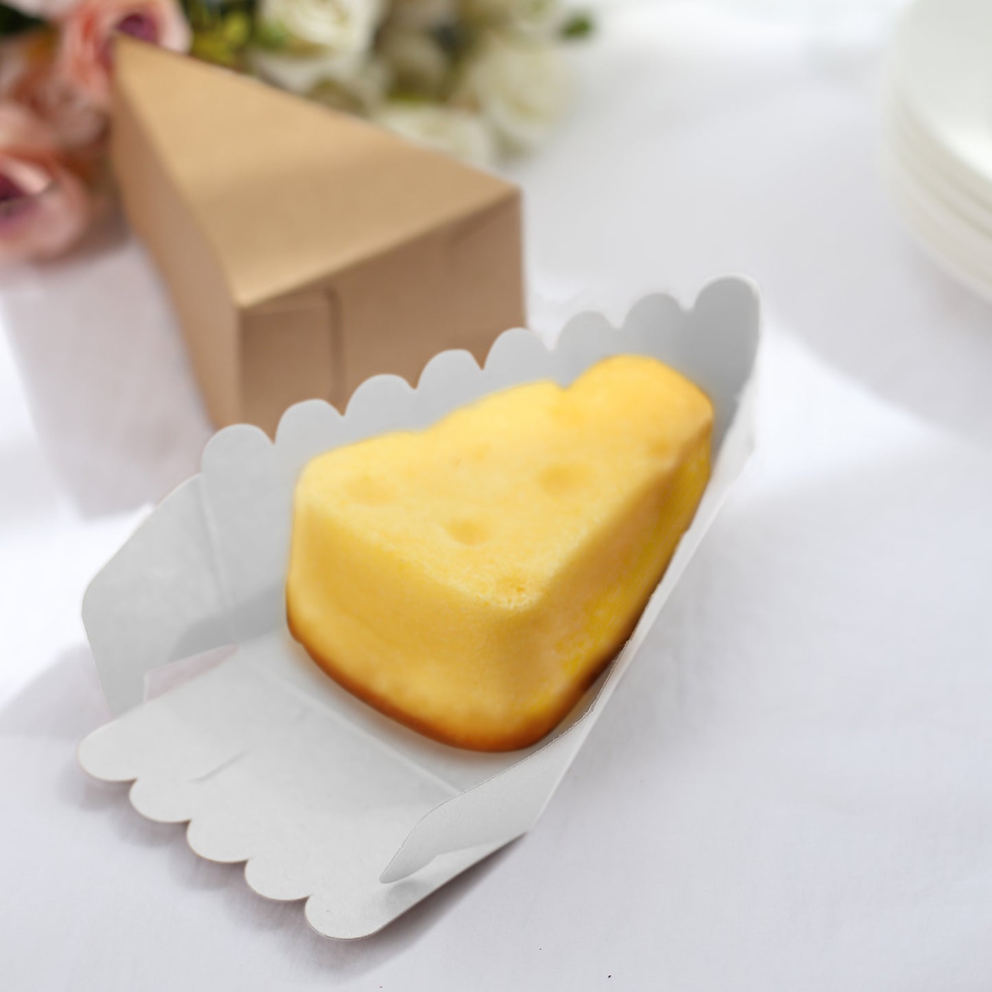 Natural brown paper cake box with a white base and a triangular dessert slice inside.