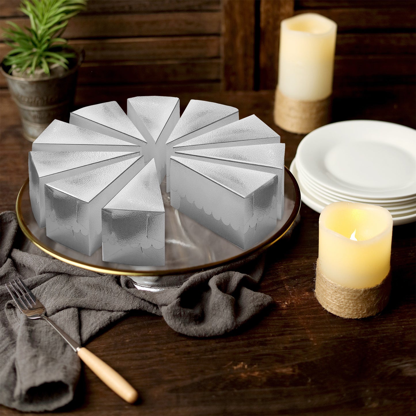 Metallic silver triangular cake boxes arranged on a serving platter.
