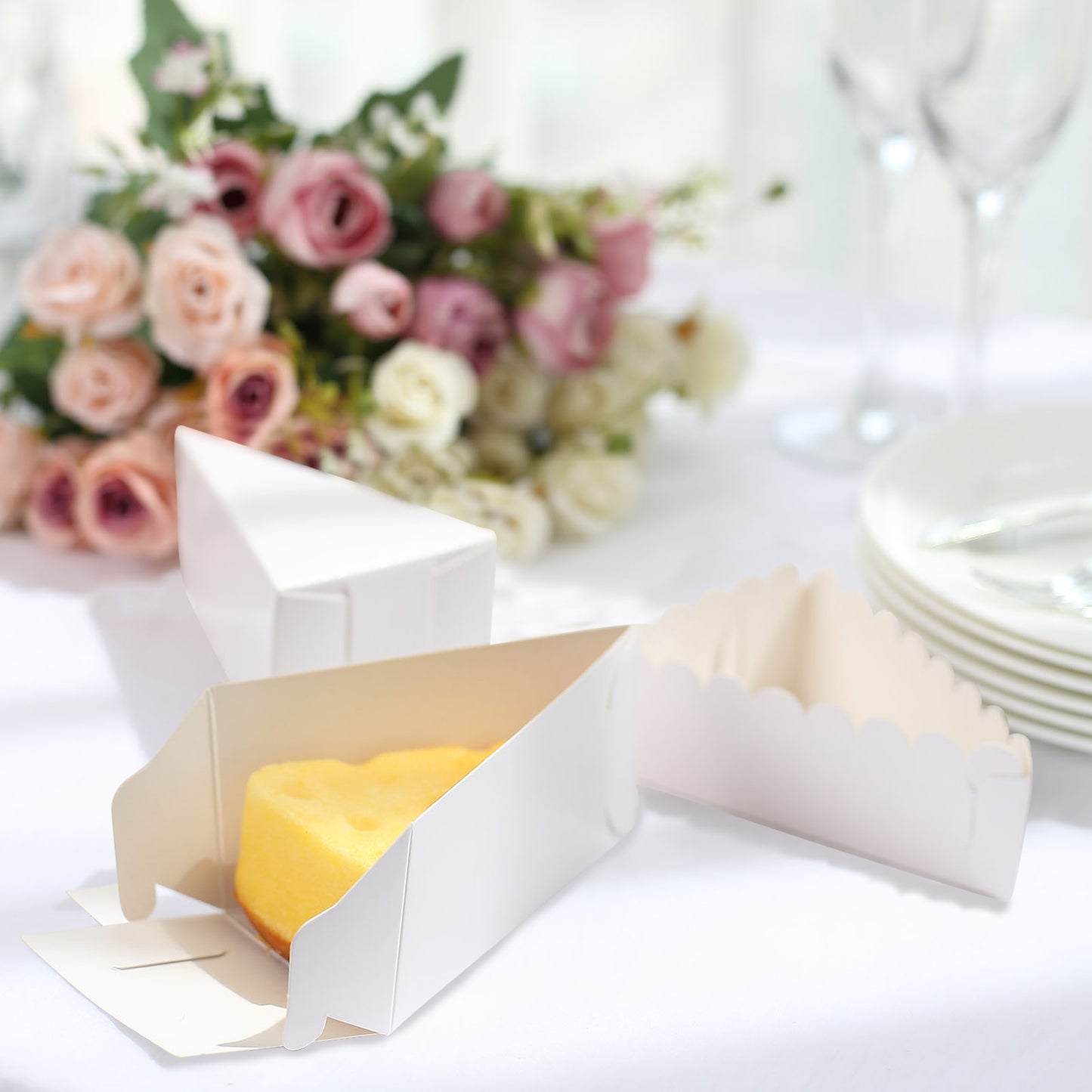 White triangular pie slice dessert box with scalloped top and yellow cake inside.