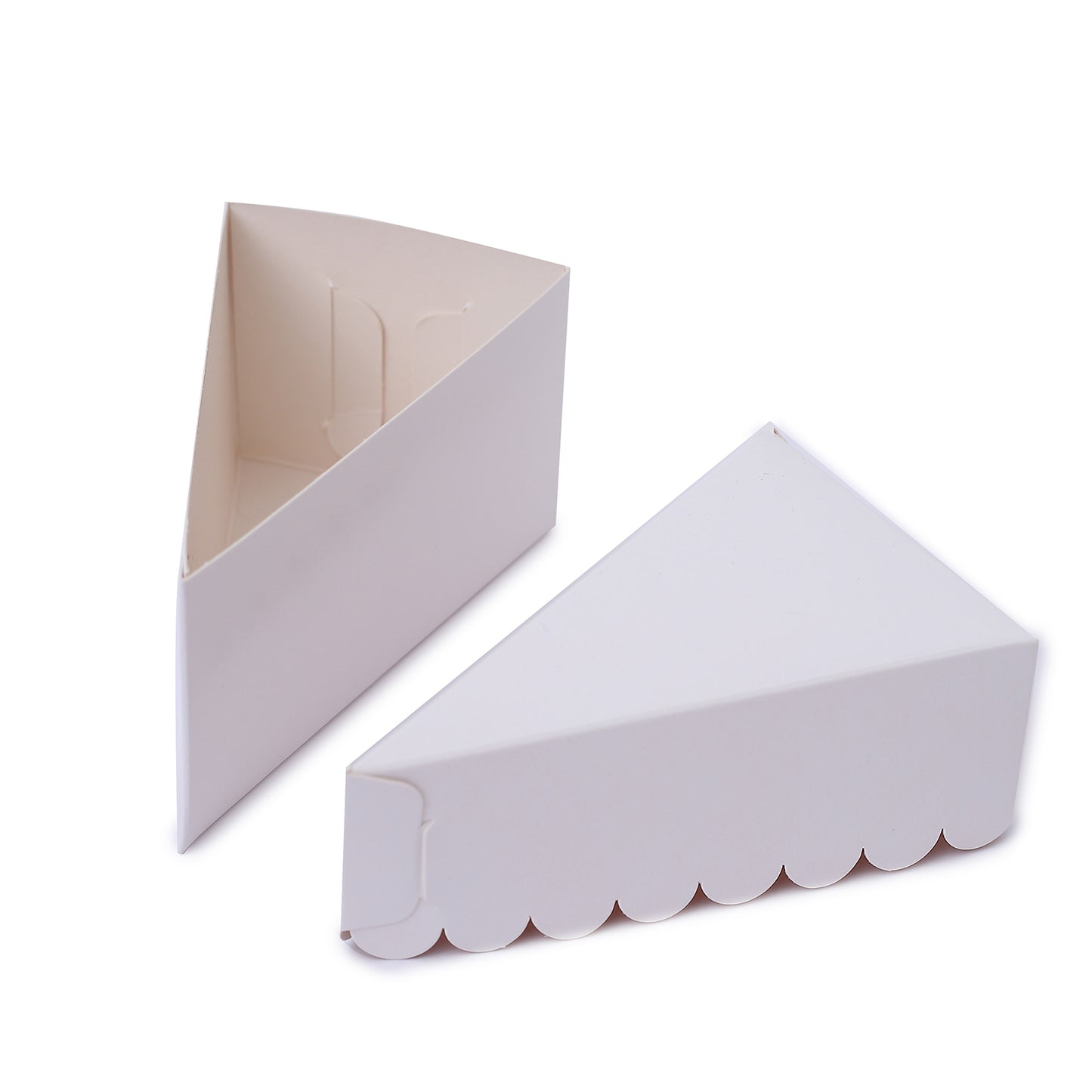 White triangular paper cake boxes with scalloped tops.