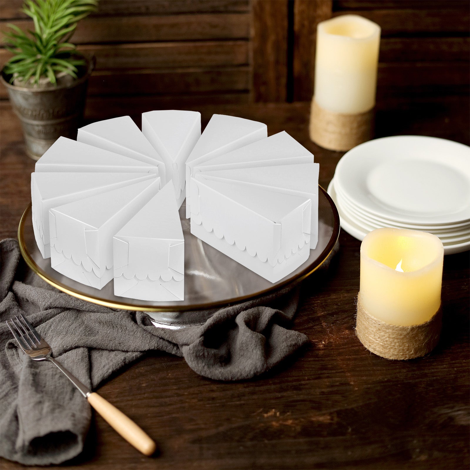 White triangular paper cake boxes arranged on a decorative plate.