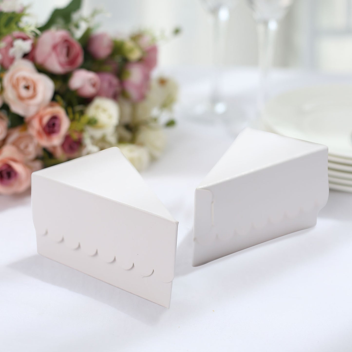 White triangular pie slice dessert boxes with scalloped tops.