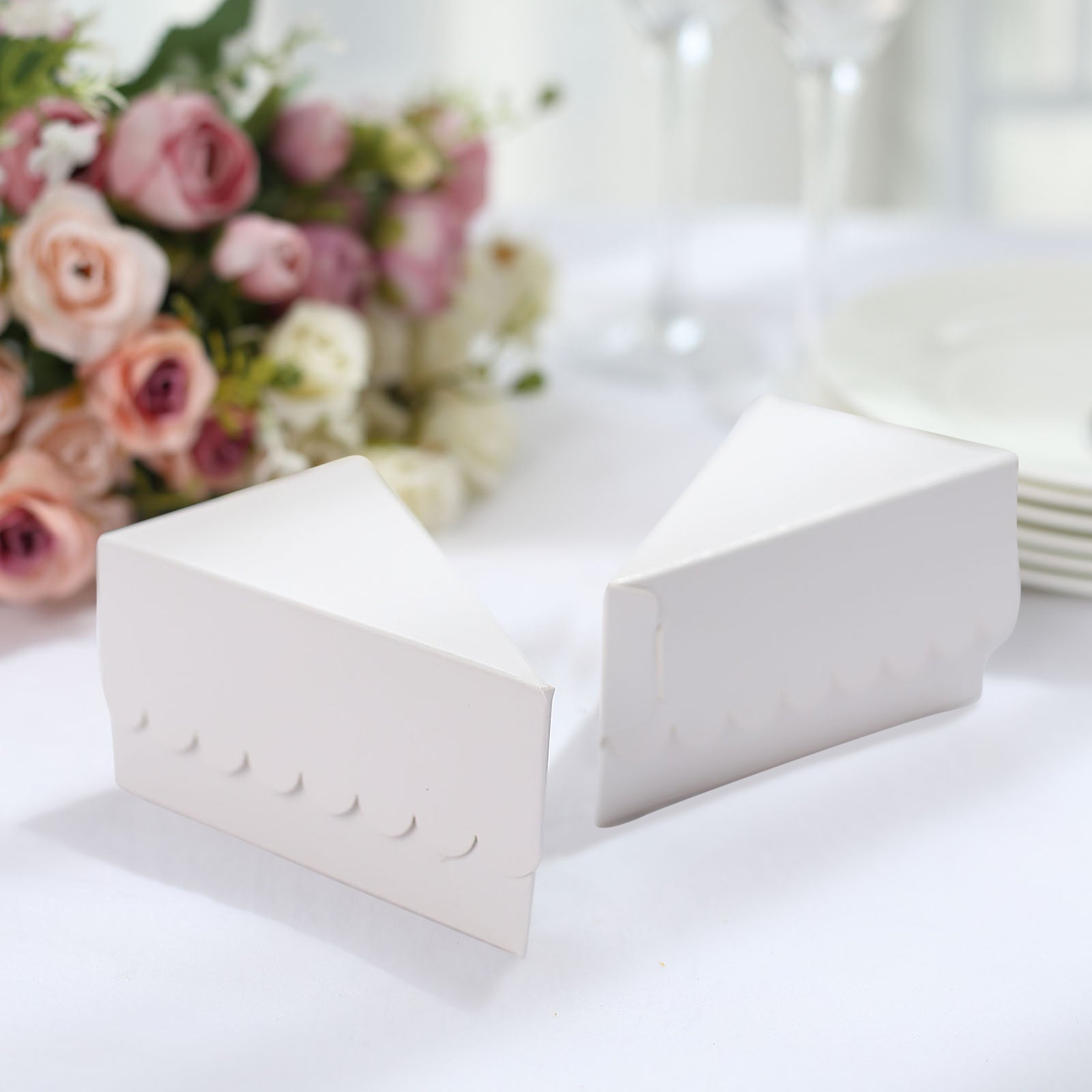 White triangular pie slice dessert boxes with scalloped tops.