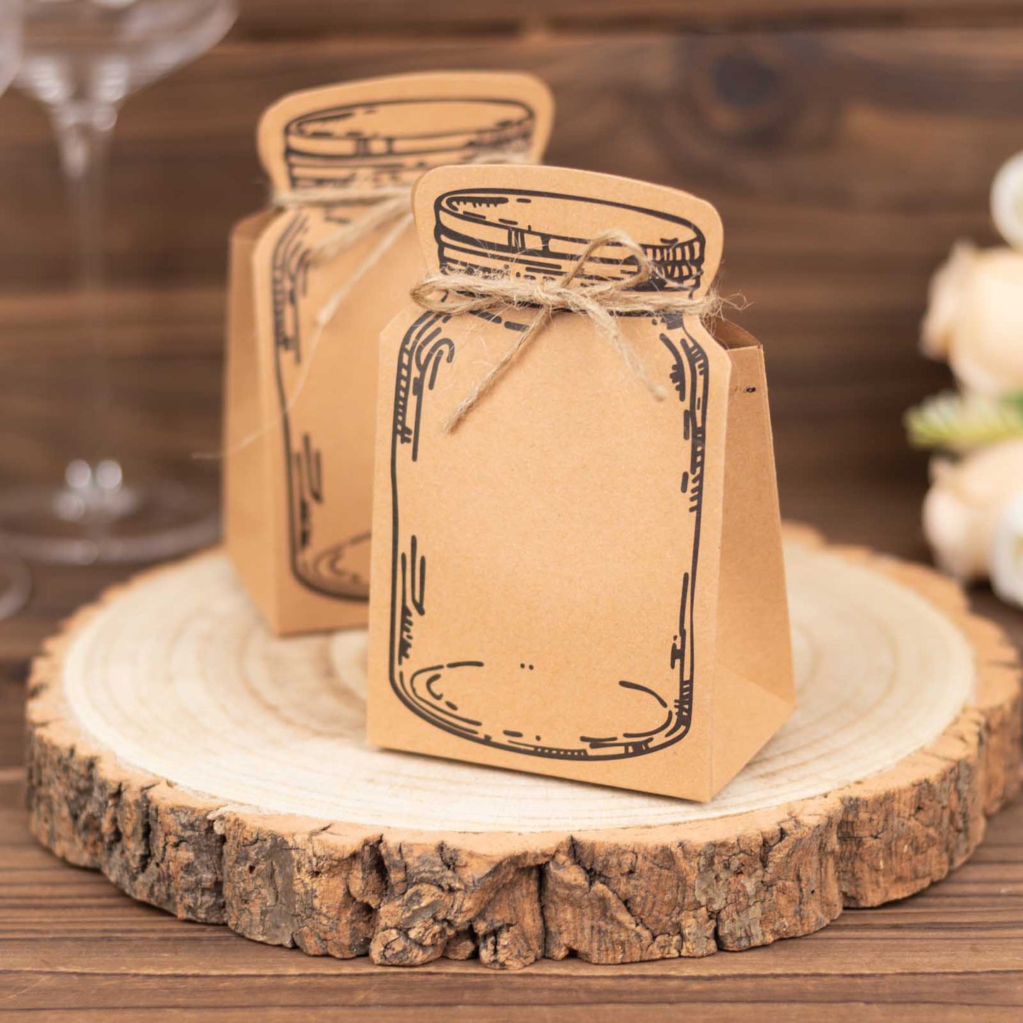 Natural mini mason jar-shaped paper favor boxes with jute rope ties.