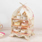 3 Tier white dessert display stand with floral print, holding cupcakes and donuts.