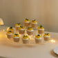 Clear acrylic half-moon display riser stand with cupcakes and decorative fruits.