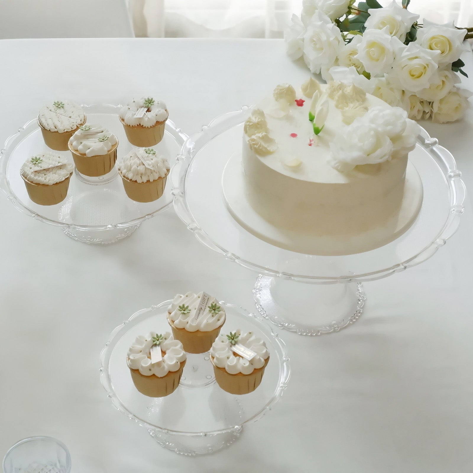 Clear plastic stackable cupcake pedestal display stands with desserts.
