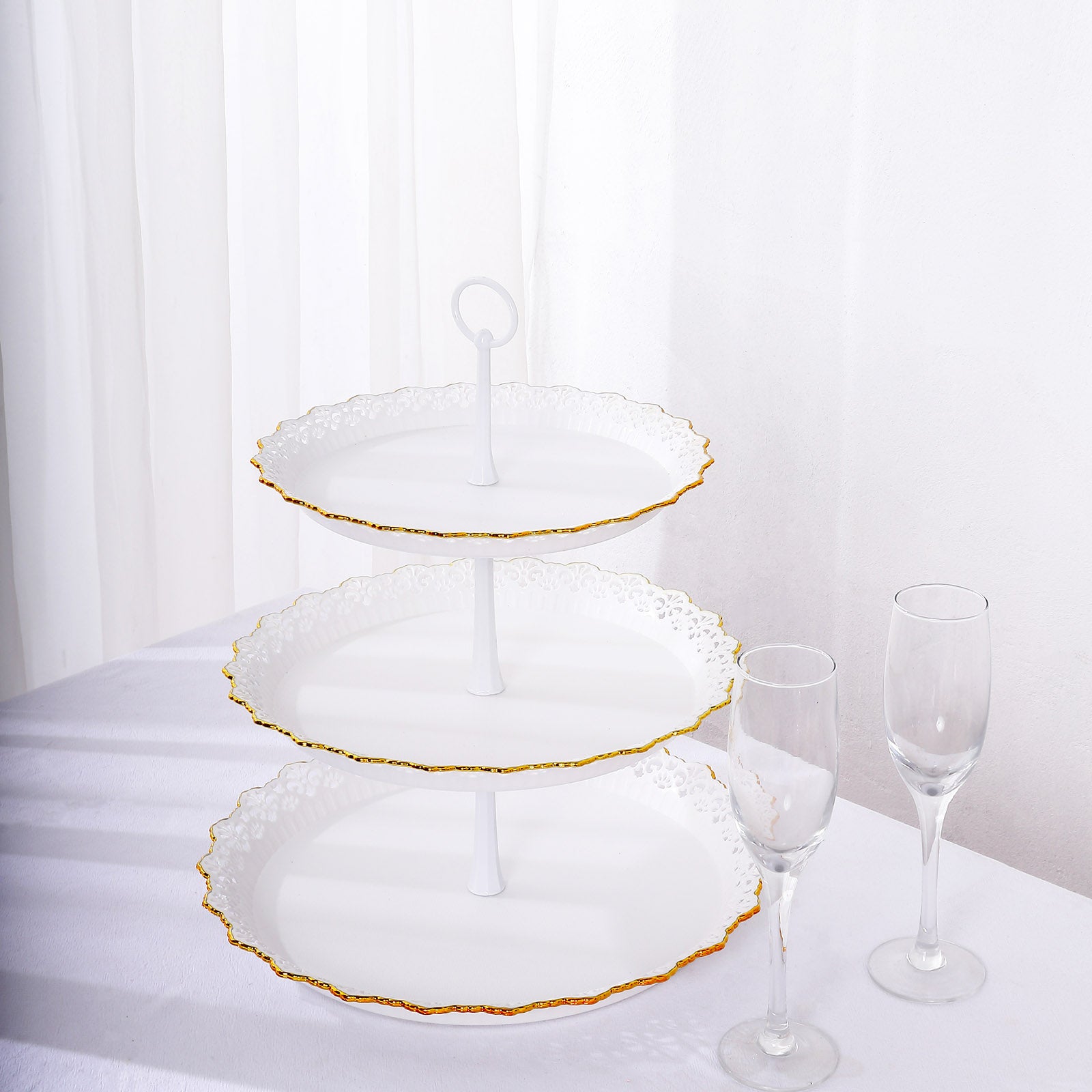 White 3-tier cupcake stand with gold rim and scalloped edges.