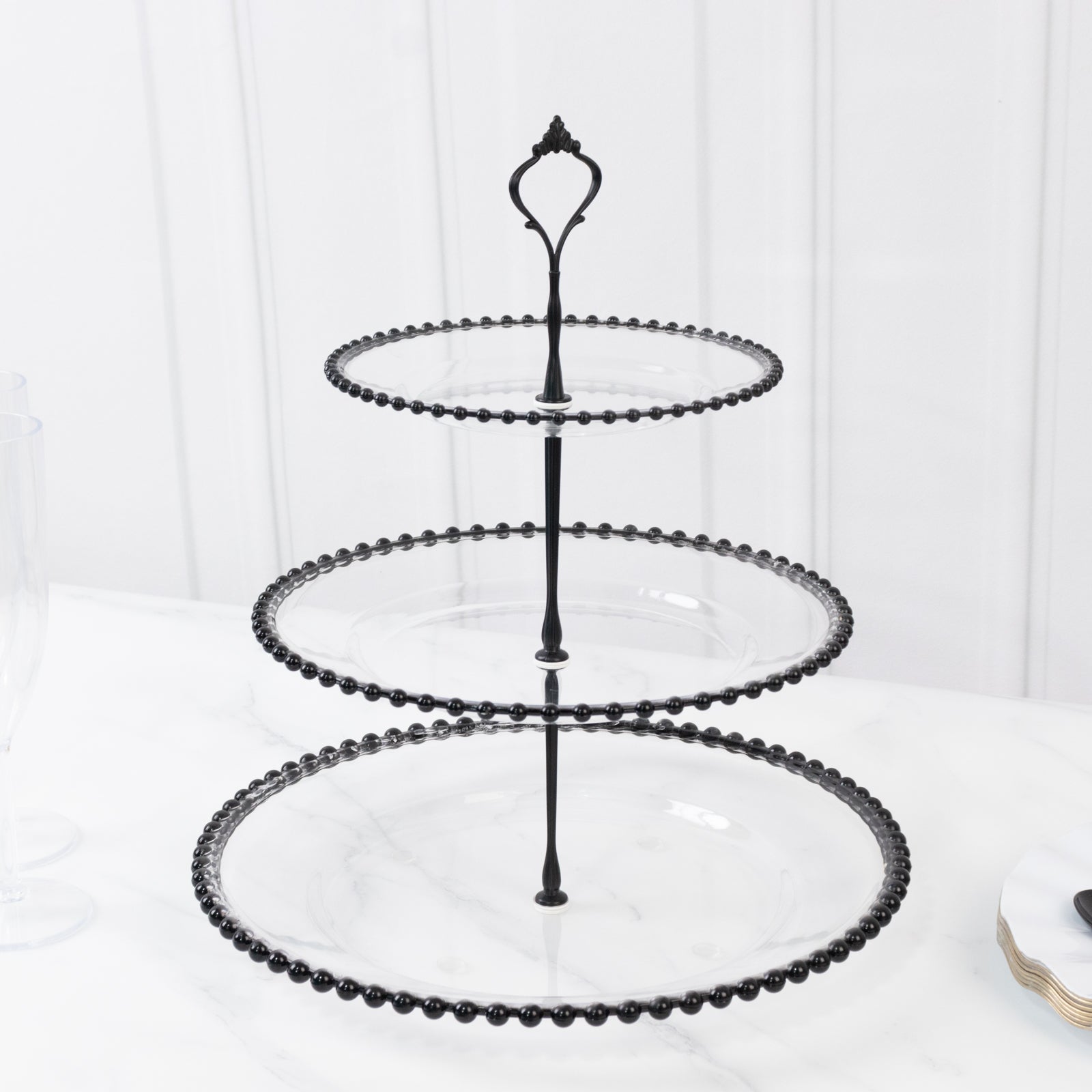 Clear 3-tier dessert stand with black beaded rim and top handle.
