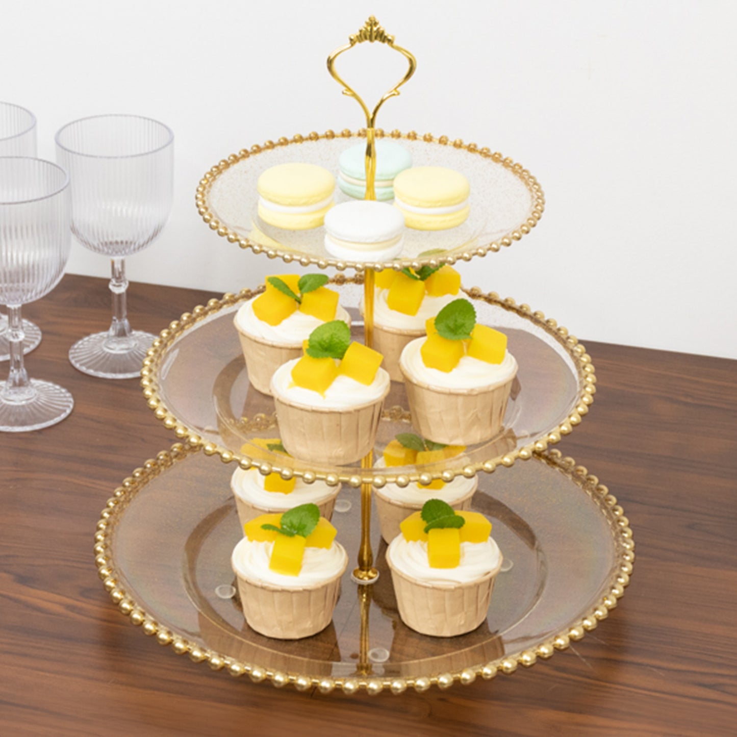 Clear gold glittered 3-tier dessert display stand with cupcakes and macarons.
