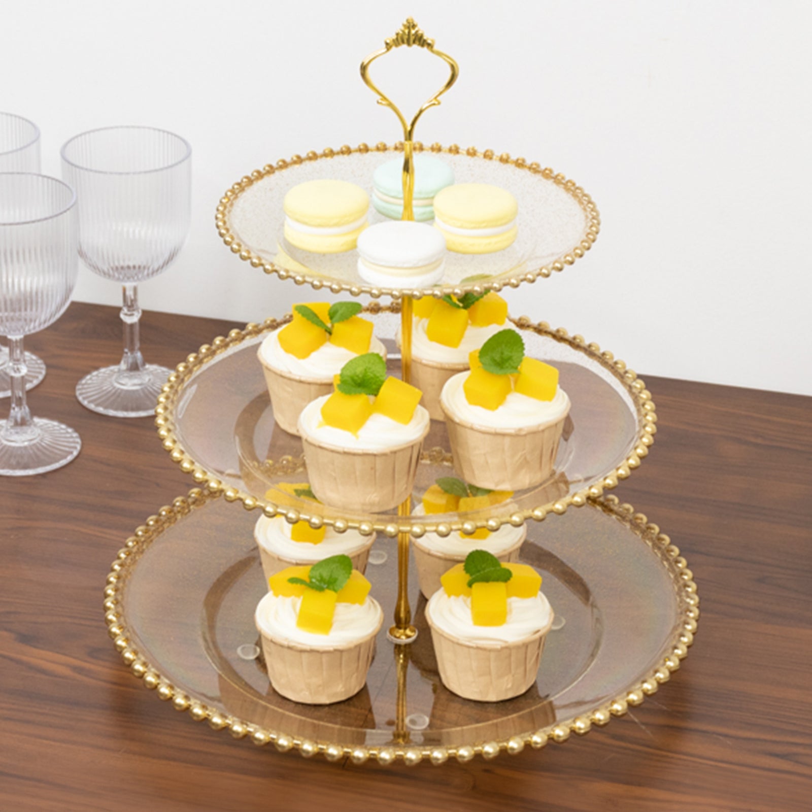 Clear gold glittered 3-tier dessert display stand with cupcakes and macarons.