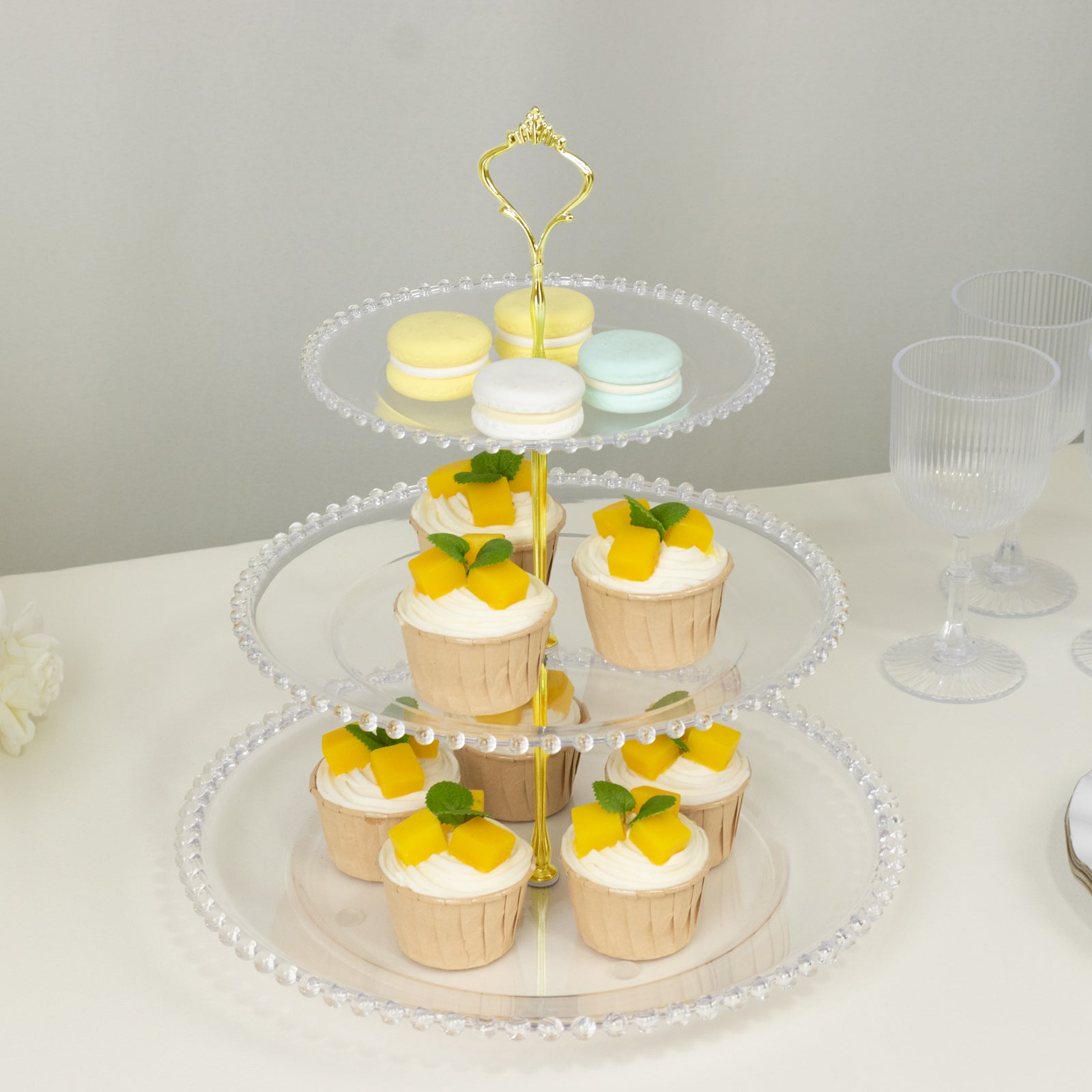 Clear 3-tier dessert display stand with cupcakes and macarons, elegant and stylish.