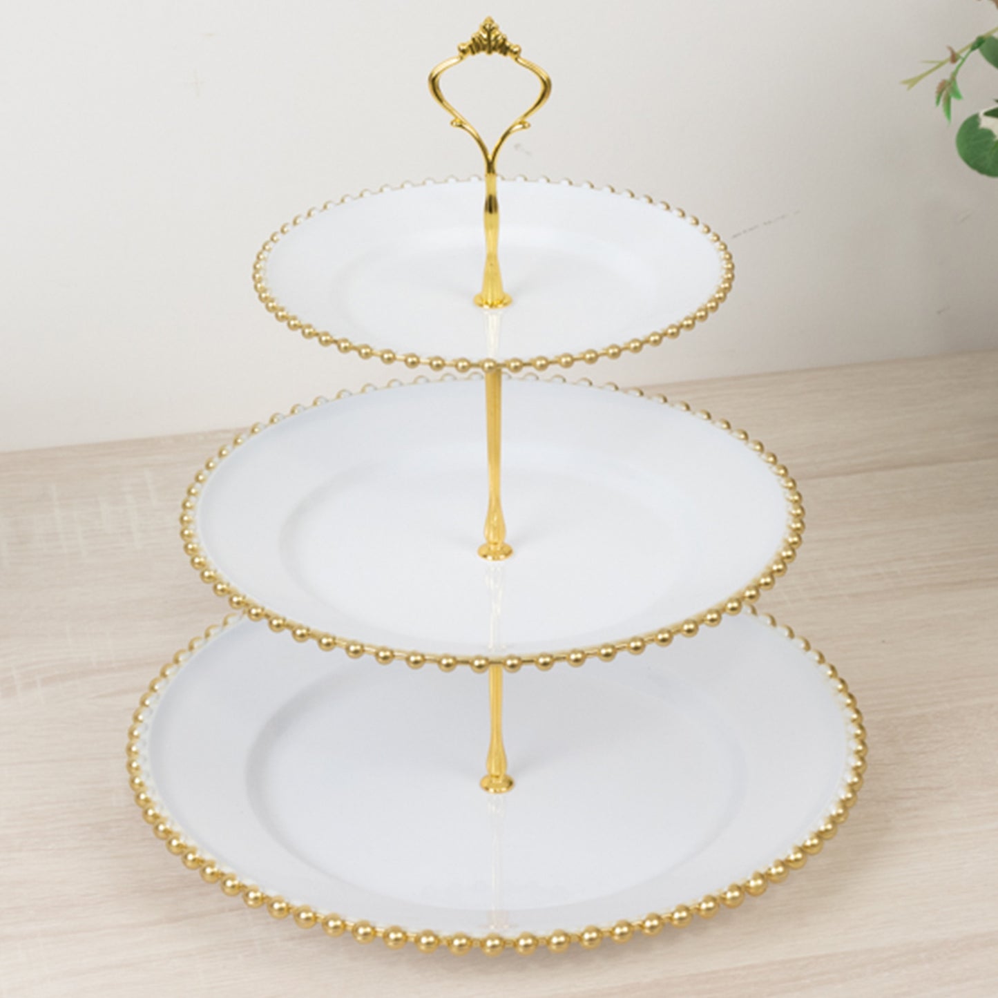 White 3-tier dessert display stand with gold beaded rim and top handle.