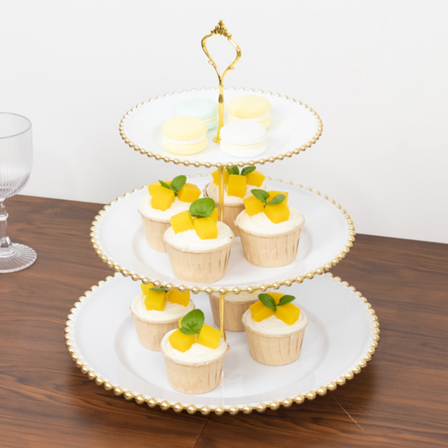 14" white 3-tier plastic dessert display stand with gold beaded rim and cupcakes.