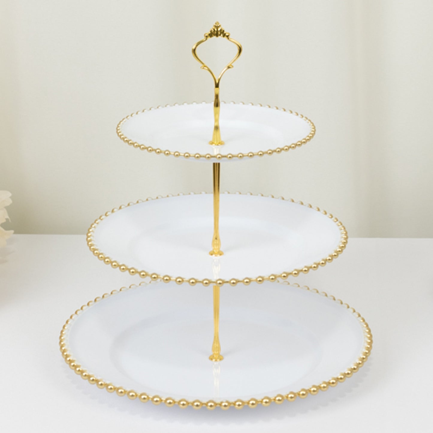 14" white 3-tier dessert display stand with gold beaded rim and top handle.