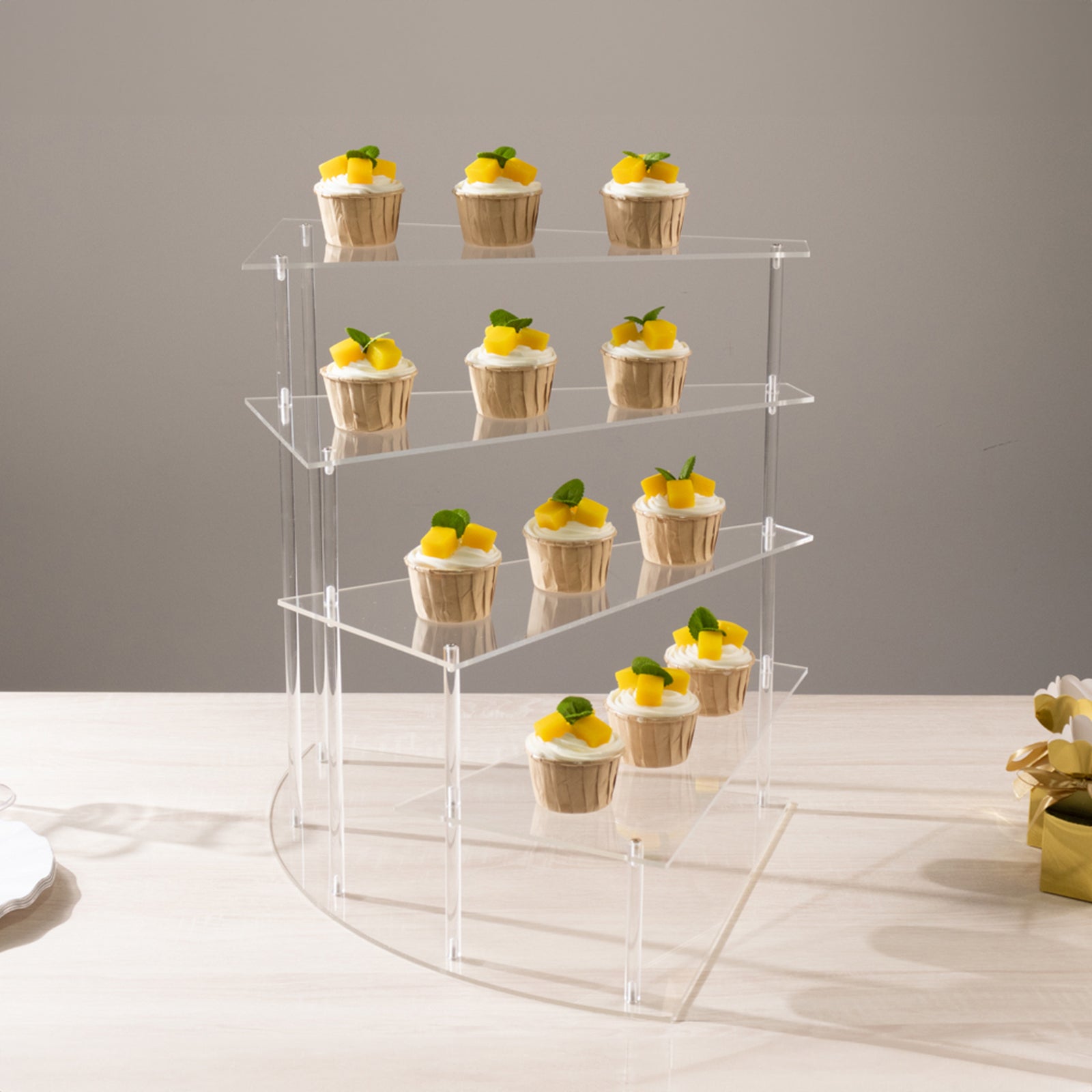 Clear acrylic 4-tier cupcake stand displaying mini desserts.