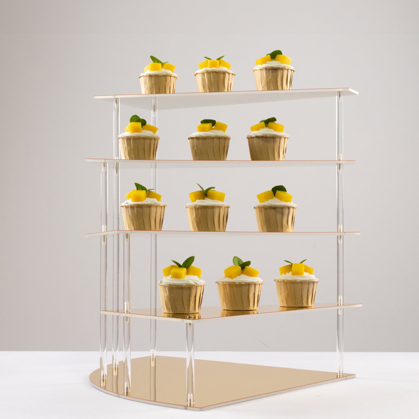 Gold acrylic cupcake stand displaying desserts with a mirror finish.