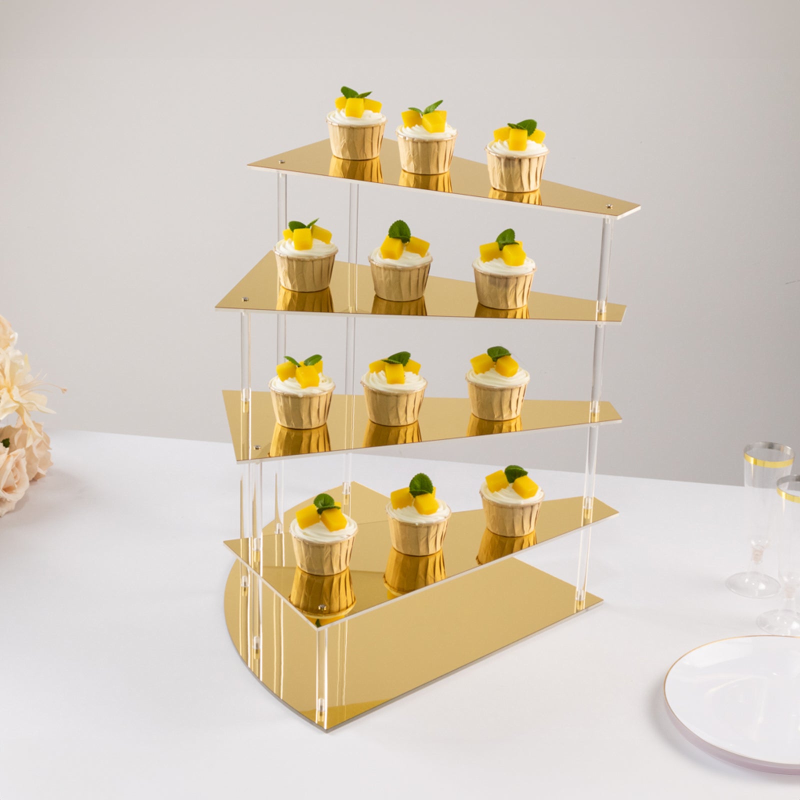 Gold acrylic cupcake stand with mirror finish displaying desserts.