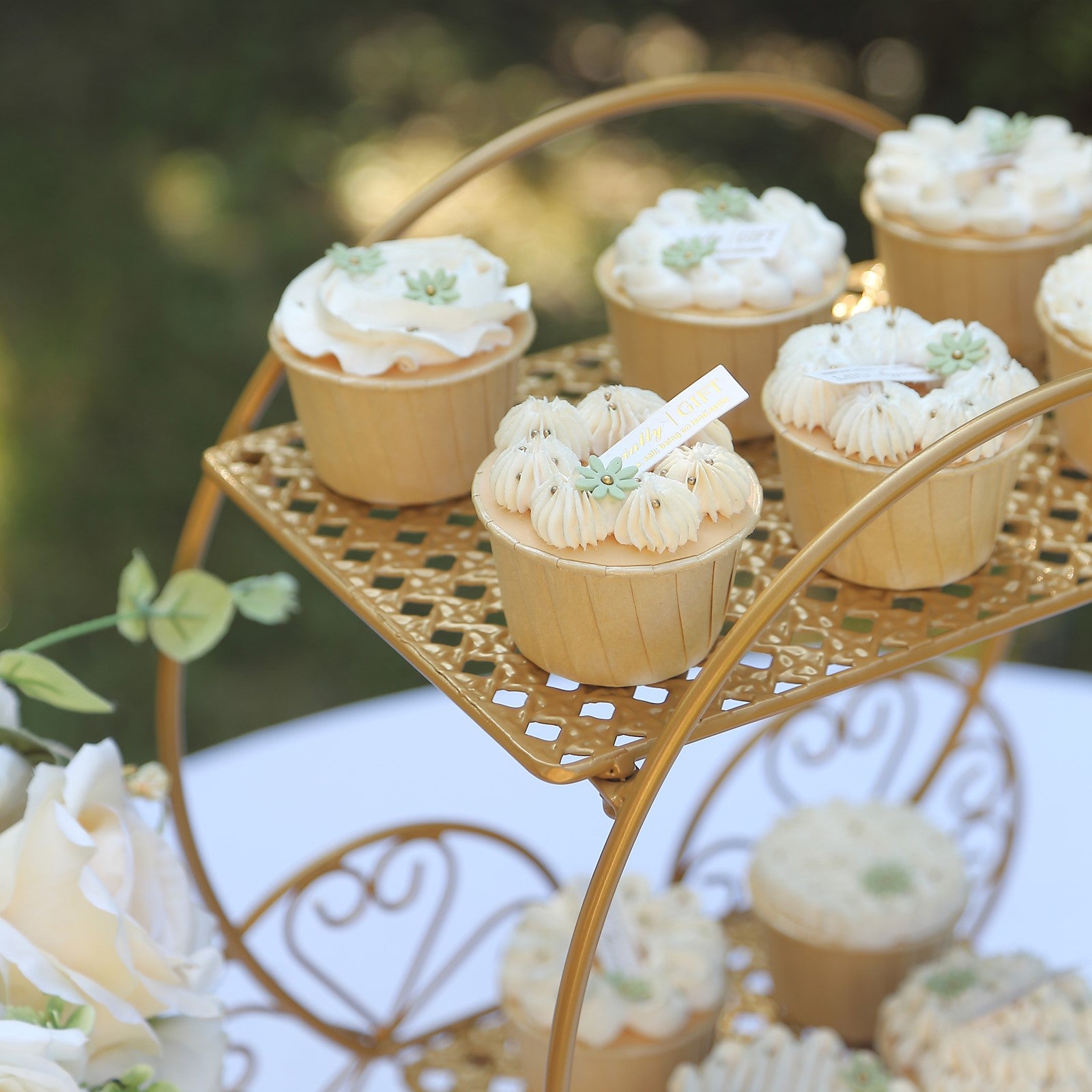 Gold 2-tier Cinderella carriage cupcake stand with elegant desserts.