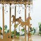 Gold carousel cake stand with hanging acrylic beads and horse designs.
