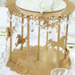 Gold carousel cake stand with hanging acrylic beads for dessert display.
