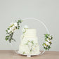 Whitewashed metal floral hoop cake stand with a beaded wooden base.