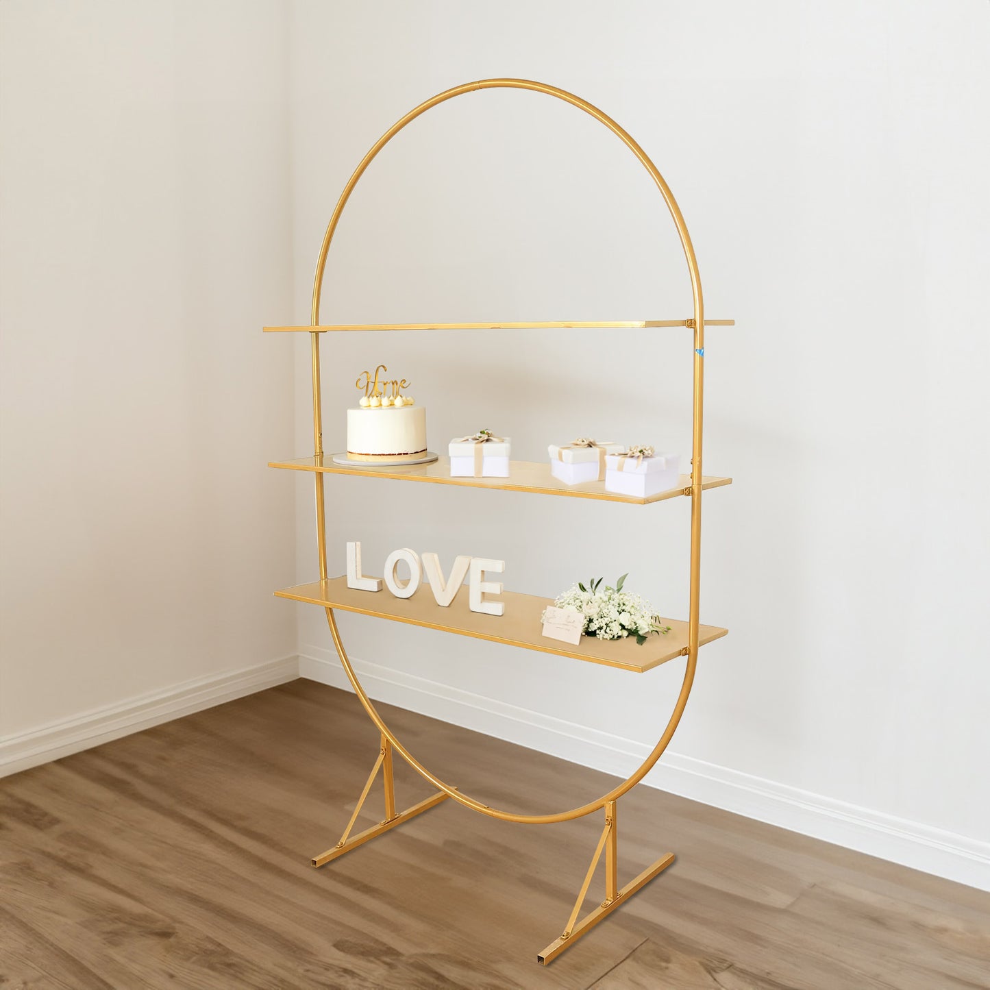 6.5ft gold metal arch cake display stand with three tiered shelves.