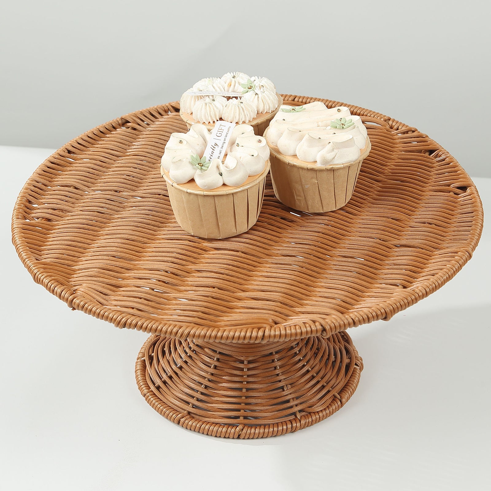 Natural rattan wicker pedestal cupcake stand with desserts on display.