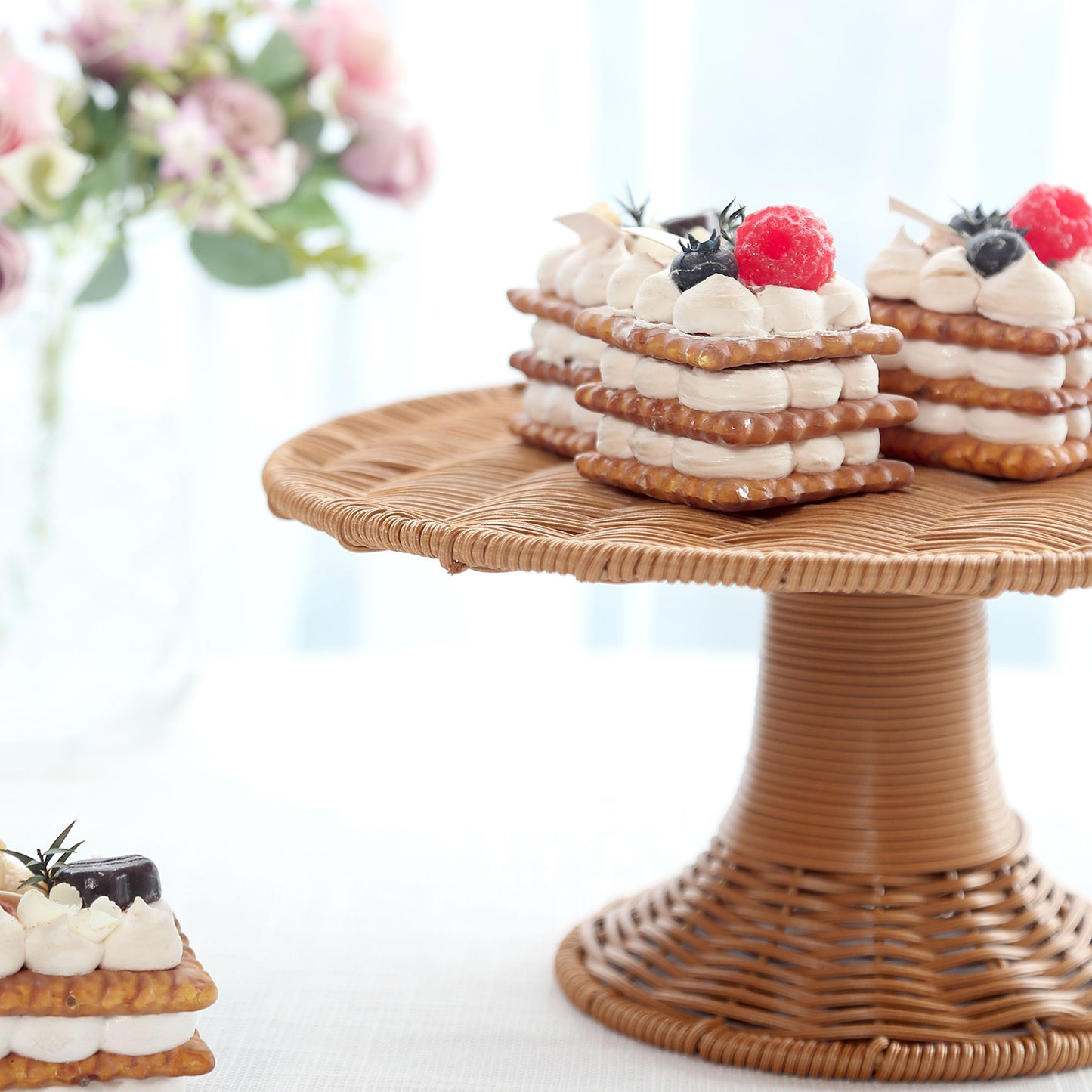 Natural rattan wicker pedestal cupcake stand with desserts on display.