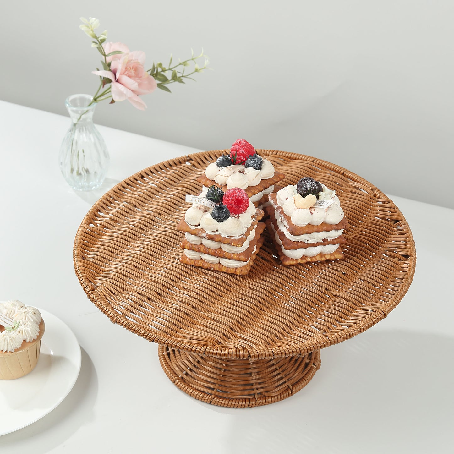 Natural rattan wicker cupcake stand displaying dessert in a rustic setting.